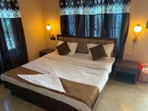 a bedroom with a large bed with pillows and curtains at The Mount lakes in Bhīm Tāl