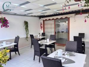 a restaurant with white tables and black chairs at Residenza Magnolia in Tropea