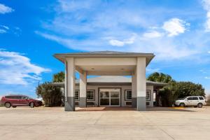 a building with a large gazebo in a parking lot at Rodeway Inn in Dilley