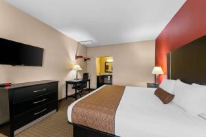 a hotel room with a bed and a flat screen tv at Rodeway Inn in Dilley +35 photos