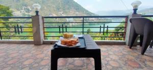 a table with a tray of food and candles on a balcony at The Mount lakes in Bhīm Tāl