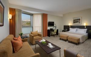 a hotel room with a bed and a living room at Ein Kerem Hotel in Jerusalem