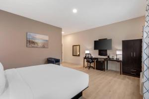 a hotel room with a white bed and a desk at Grant Street Inn, an Ascend Collection Hotel in Dunedin
