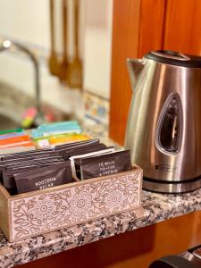 a counter with a tea kettle and a box of books at Hostal El Horno in Molinaseca