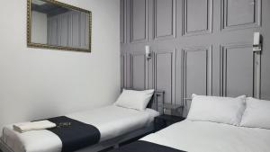 a room with two beds and a mirror on the wall at Holiday Plus - 50 Palatine Road in Blackpool