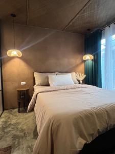 a bedroom with a large bed and a window at Kundiman Siargao, General Luna in General Luna