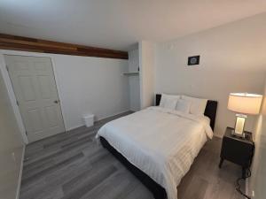 a bedroom with a white bed and a white door at Spacious 3-Bedroom Private Guest Suite in Inuvik