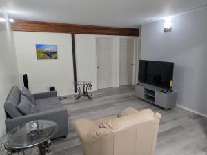 a living room with a couch and a tv at Spacious 3-Bedroom Private Guest Suite in Inuvik