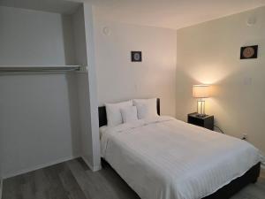 a bedroom with a large bed with white sheets and pillows at Spacious 3-Bedroom Private Guest Suite in Inuvik