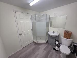 a bathroom with a shower and a toilet and a sink at Spacious 3-Bedroom Private Guest Suite in Inuvik