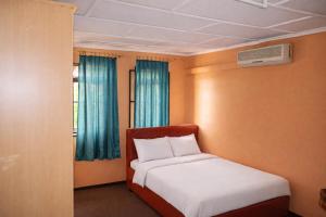 a small bedroom with a bed and a window at Rico Home Stay in Nkotunsi