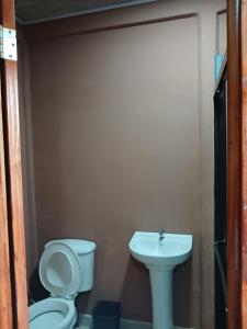 a bathroom with a toilet and a sink at Cabinas El Mirador in Canoas
