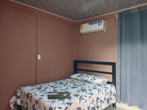 a bedroom with a bed and a air conditioner at Cabinas El Mirador in Canoas