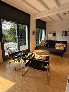 ein Wohnzimmer mit Sofa, Tisch und Stühlen in der Unterkunft Guesthouse Monte Verità in Ascona