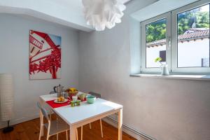 a kitchen with a white table and two windows at Apartamento luminoso y espacioso en Urdaibai in Elanchove