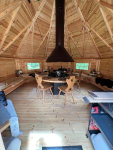 a room with a table and chairs in a cabin at Loray des Bois - Cabane - Tipi - Cottage in Loray