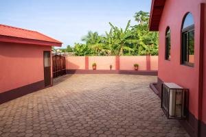 an empty courtyard of a house with pink walls at Rico Home Stay in Nkotunsi