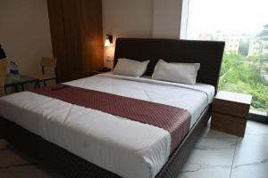 a large bed in a room with a large window at HOTEL RV PARK Inn MOGAPPAIR in Chennai