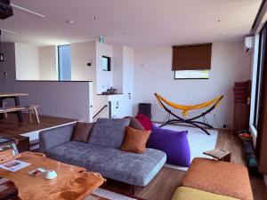 a living room with a couch and a television at Private Ocean Resort YUUNAGI in Awaji