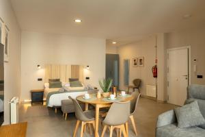 a bedroom with a bed and a table and chairs at Apartamentos Villa De Comillas in Comillas