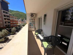 a balcony with chairs and a table on a building at Olive Square Apartment Budva in Budva