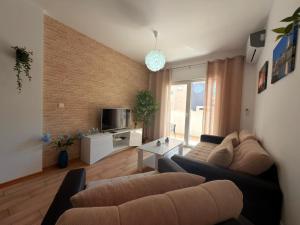 a living room with a couch and a table at Olive Square Apartment Budva in Budva