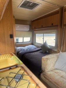 a room with two beds and a couch in an rv at Caravans through the nature in Mikhmoret
