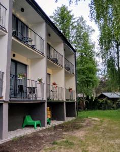 an apartment building with balconies and a green bench at SANSET APART Okuninka in Okuninka