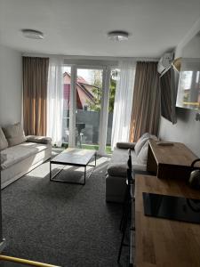 a living room with a couch and a table at SANSET APART Okuninka in Okuninka