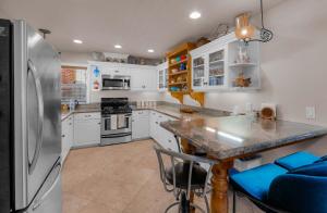 a kitchen with a stainless steel refrigerator and a table at Royal Retreat Quiet & Cozy in South Lake Tahoe