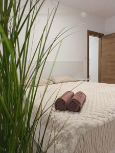 a bed with two brown towels on it at Boutique apartment yellow 1 in Plovdiv