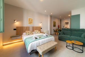 a bedroom with a bed and a green couch at Apartamentos Villa De Comillas in Comillas