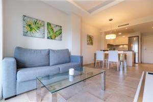 a living room with a blue couch and a table at Nicolas in Casas Devesa