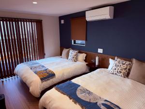 a bedroom with two beds and a window at Private Ocean Resort YUUNAGI in Awaji +138 photos