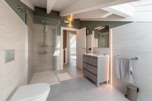 a bathroom with a shower and a toilet and a sink at Apartamentos Villa De Comillas in Comillas +155 photos