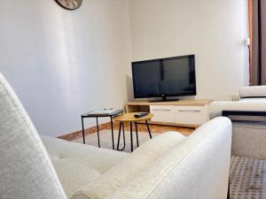 a living room with two chairs and a television at La Maison Du Belvedere in Saint-Cyprien