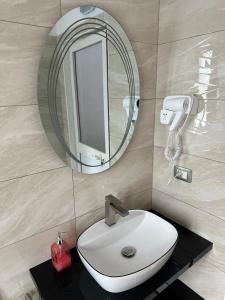 a bathroom with a white sink and a mirror at Bujtina Valgent in Berat