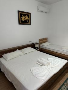 a bedroom with two beds with white sheets at Bujtina Valgent in Berat