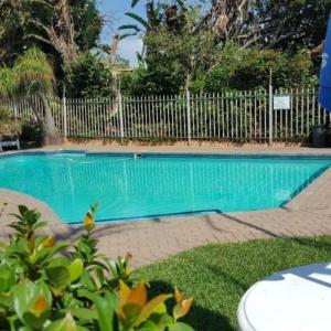 a swimming pool in a yard with a fence at Mangrove Beach Estate Boboyi in Port Shepstone