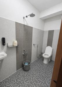 a bathroom with a toilet and a sink at Cloud Valley Inn in Cherrapunji