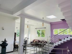 a living room with purple walls and a purple staircase at Shanuka homes in Mawanella