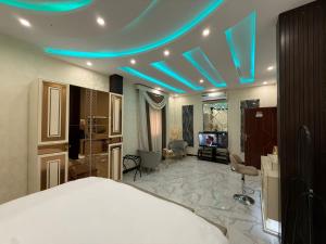 a bedroom with a bed and a blue light at شقق مباركية in Rafha