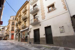 a building on a street in a city at Apartamento Silleria Reyes Catolicos Centro in Granada
