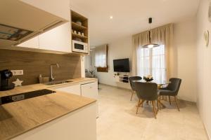 a kitchen and dining room with a table and chairs at Apartamento Silleria Reyes Catolicos Centro in Granada