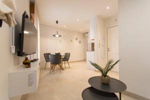 a living room with a table and a dining room at Apartamento Silleria Reyes Catolicos Centro in Granada