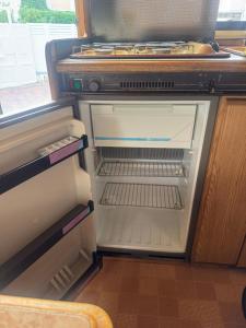 an empty refrigerator with its door open in a kitchen at Caravans through the nature in Mikhmoret