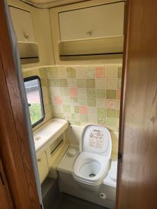 a small bathroom with a toilet in an rv at Caravans through the nature in Mikhmoret +43 photos
