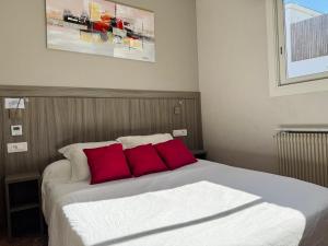 a bedroom with a bed with two red pillows at La Maison Du Belvedere in Saint-Cyprien +20 photos