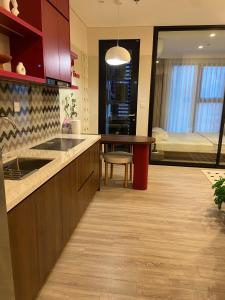 a kitchen with a sink and a table in a room at Cherry Home in Ðan Phô