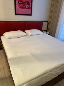a large white bed with two pillows on it at Cherry Home in Ðan Phô